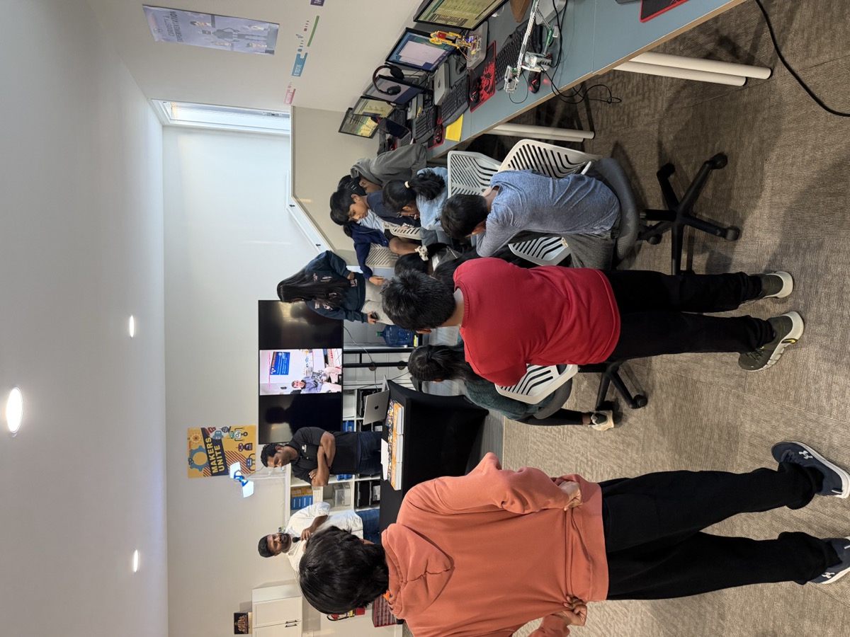 Code Hero Academy students collaborating at workstations before the badge ceremony